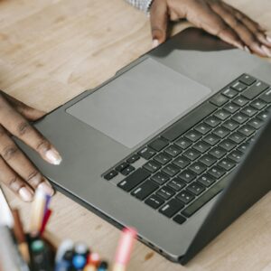 Close-up of woman's hands on laptop keyboard in a professional office environment, perfect for business or tech themes.