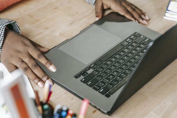 Close-up of woman's hands on laptop keyboard in a professional office environment, perfect for business or tech themes.