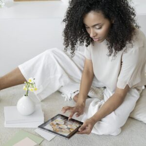 Creative woman using a tablet for design planning in a modern, relaxed setting.